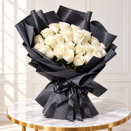 Left-side view of white roses showing the layered black wrap and ribbon