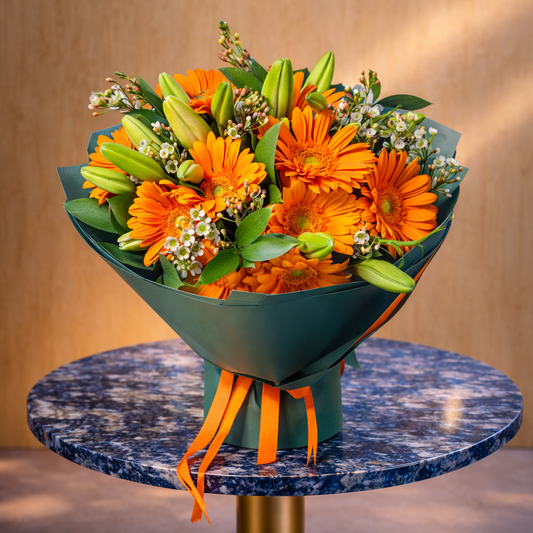 red gerbera flower arrangement with lilies and decorative wrap
