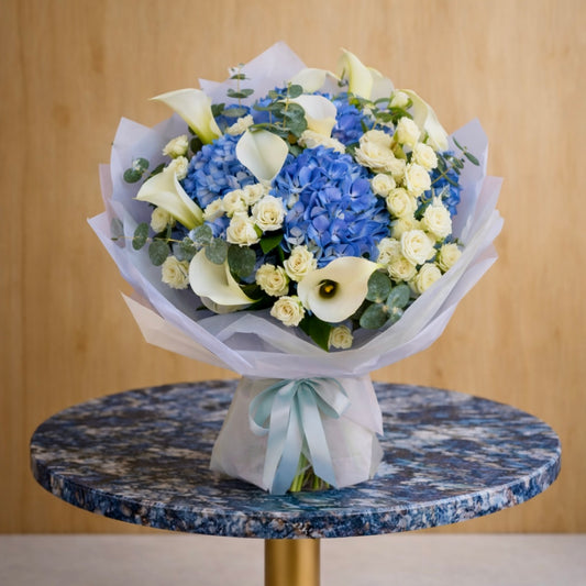 elegant blue and white flower arrangement wrapped in soft paper