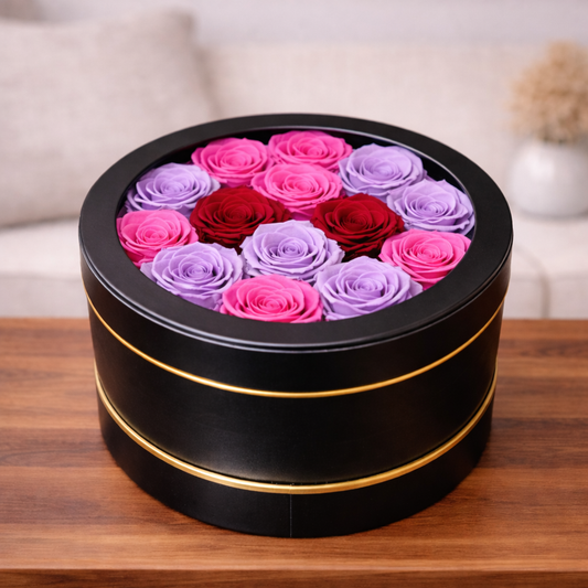 Luxury eternal roses arranged in a round black flower box with pink and purple tones