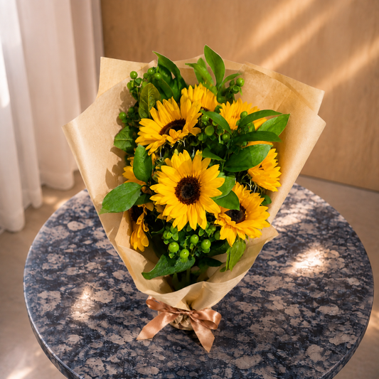 Top view of Golden Glow sunflower bouquet with green berries and natural kraft wrapping