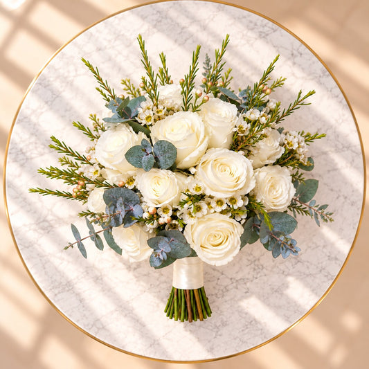 Side view of an ivory bridal bouquet with white roses and satin-wrapped stems