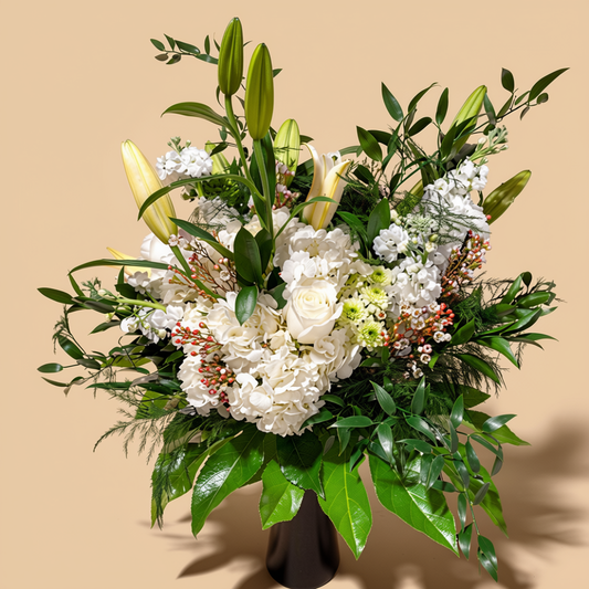 Garden-style flower arrangement with hydrangeas and roses in a glass vase