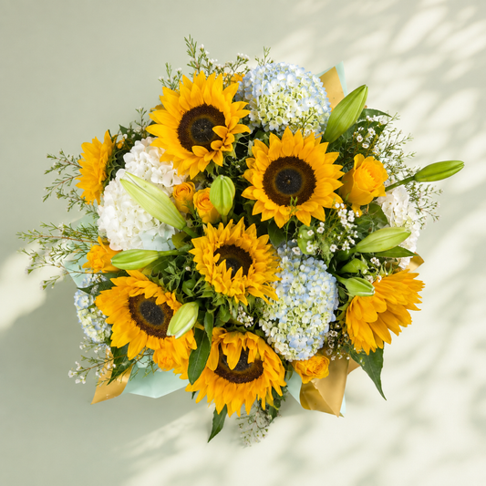 Top view of Sunlit Garden with yellow sunflowers, blue hydrangeas, lily buds and seasonal greenery