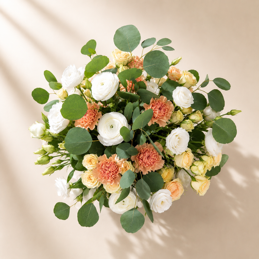 Top view of champagne rose flower arrangement with blush flowers and greenery