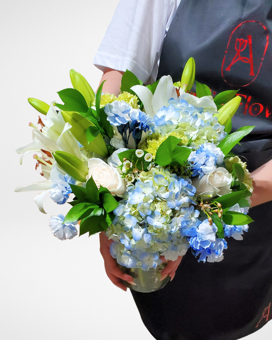 White lilies and blue hydrangeas floral arrangement