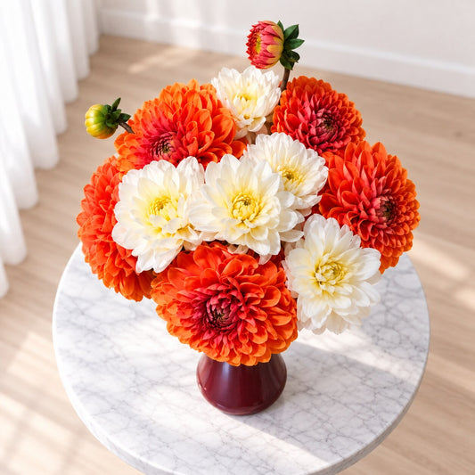 Autumn dahlia arrangement with orange and ivory flowers viewed from above