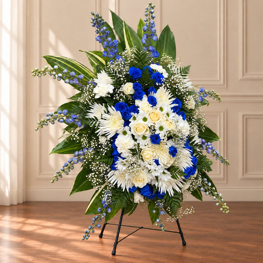 Blue and white sympathy flowers arranged as an elegant easel tribute for a funeral service