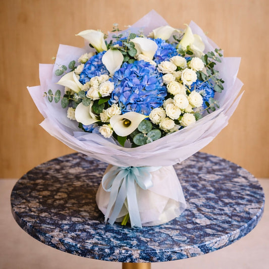 Bouquet of blue and white flowers on a marble table