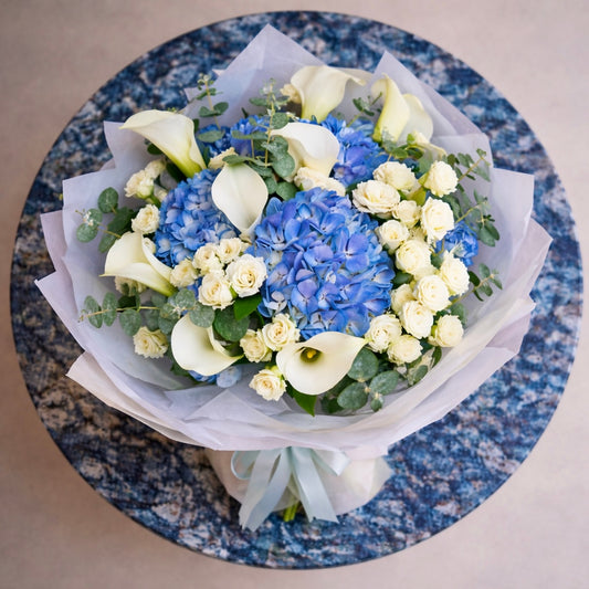 top view of blue and white flowers arranged in a round bouquet