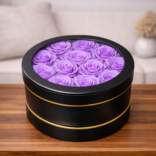 Purple preserved roses inside an elegant black hat box on wooden table
