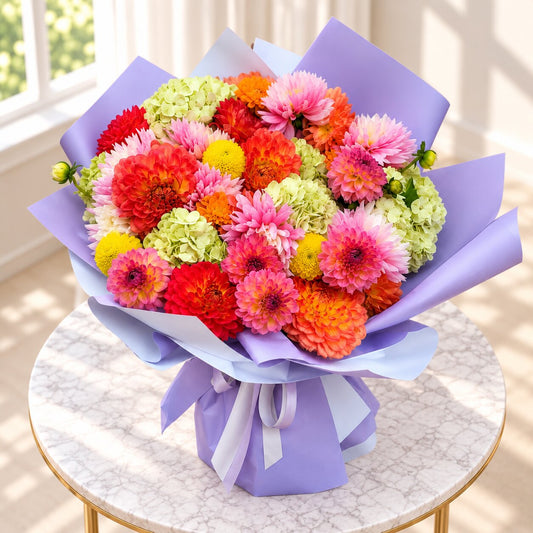 Top view of The Kaleidoscope luxury dahlia bouquet in vibrant pink coral and orange tones