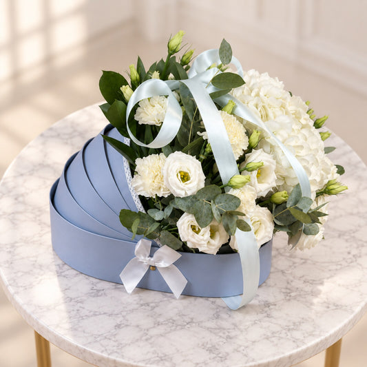 Top view of Tender Beginnings with white lisianthus, hydrangeas, roses and pale blue ribbons