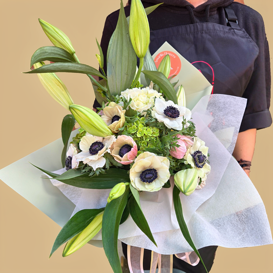 Handcrafted floral arrangement with white blooms and greenery