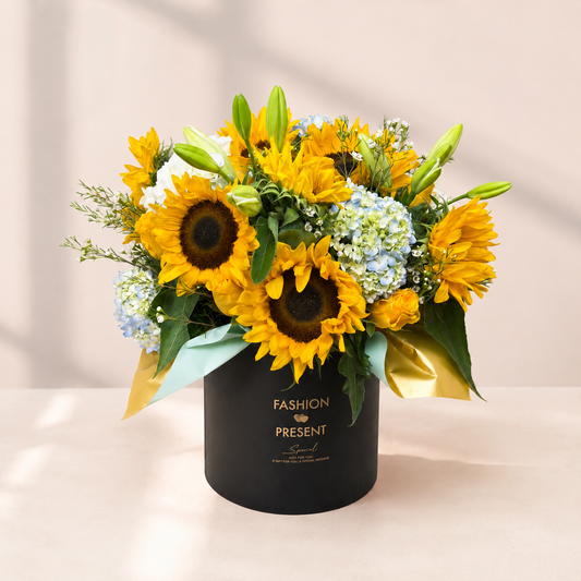 Sunlit Garden sunflower arrangement in Toronto with blue hydrangeas, yellow roses and a black floral box