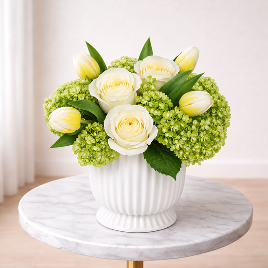 Front view of Citrus & Cream white rose centerpiece with yellow tulips and green hydrangeas in Toronto