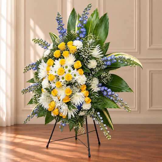 Golden yellow roses and white memorial flowers in a handcrafted easel arrangement by Amarilis Flowers